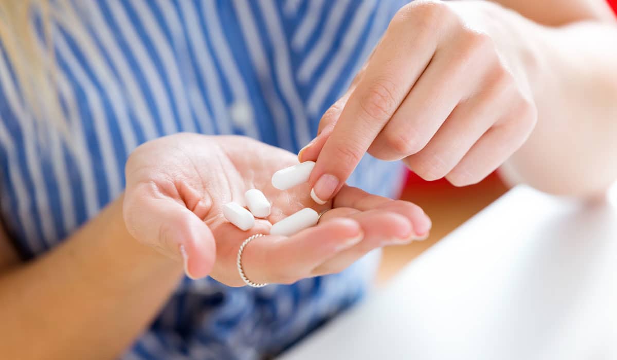 Woman taking a probiotic for Candida overgrowth